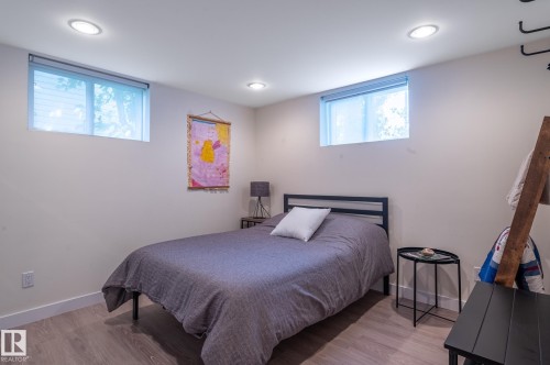 Room featuring wood-finish flooring, recessed ceiling lighting, and two windows with roller shades - 11634 74 Avenue Nw, Edmonton, AB 