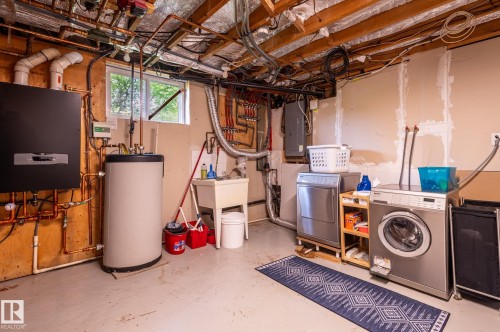 Utility room featuring a laundry sink, exposed copper plumbing, and a water heater - 11634 74 Avenue Nw, Edmonton, AB 