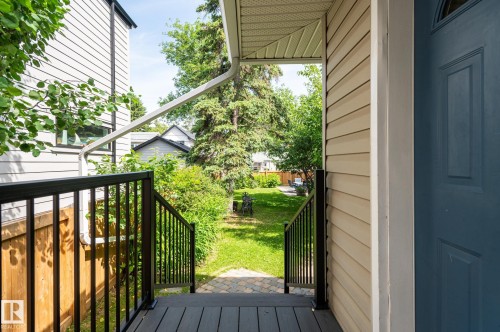 Exterior porch featuring composite decking and black metal railings - 11634 74 Avenue Nw, Edmonton, AB 