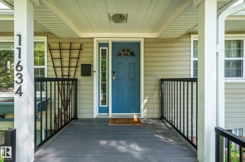 Covered front porch featuring durable composite decking and black metal railings - 11634 74 Avenue Nw, Edmonton, AB 