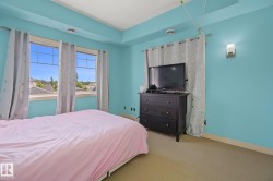 Room featuring two large windows, a tray ceiling, and wall-mounted lighting - 
