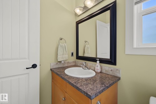 Bathroom vanity with a dark speckled countertop, undermount sink, and chrome faucet - 30 2565 Hanna Crescent, Edmonton, AB 