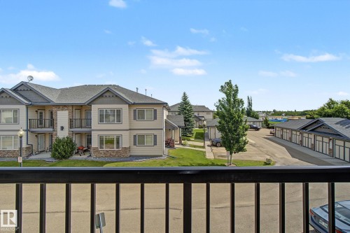 Multi-story residential buildings featuring balconies, stone accents, and dark pitched roofs - 30 2565 Hanna Crescent, Edmonton, AB 