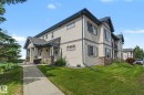 Exterior features include multi-level architecture, beige siding, dark trim, stone accents, and a covered entry porch - 30 2565 Hanna Crescent, Edmonton, AB 