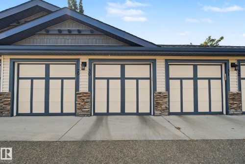 Modern garage doors featuring paneling and transom-style windows - 30 2565 Hanna Crescent, Edmonton, AB 