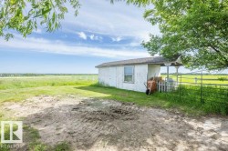 White outbuilding with a single window and covered porch area - 