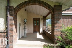 Brick archway entry featuring a wood-panel ceiling and stucco facade - 