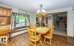 Dining area featuring wood-finish flooring and a bay window with a built-in window seat - 