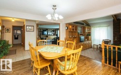 Dining area featuring wood-finish flooring and a central chandelier - 
