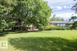 Spacious front yard with mature trees and a manicured lawn - 