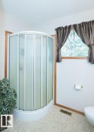 Corner shower enclosure with frosted glass panels and a white base - 