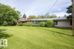 Expansive green lawn with mature trees and established landscaping - 