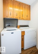 Laundry area featuring wood-finish flooring and light-toned walls - 