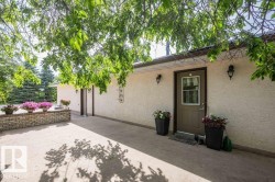 Exterior entryway featuring a brown door with a window insert, two wall-mounted sconces, and stucco siding - 