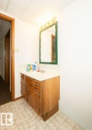 Bathroom vanity featuring a wood-finish cabinet with double doors and a single drawer - 