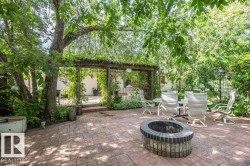 Expansive brick paver patio featuring a built-in fire pit - 