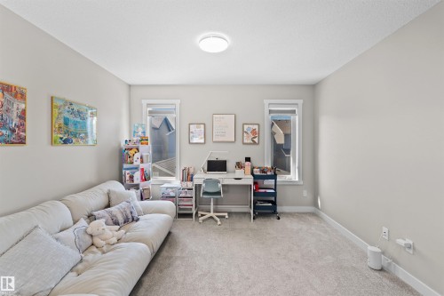 Carpeted room with light gray walls, two windows, and a flush-mount ceiling light fixture - 4673 Alwood Way, Edmonton, AB 