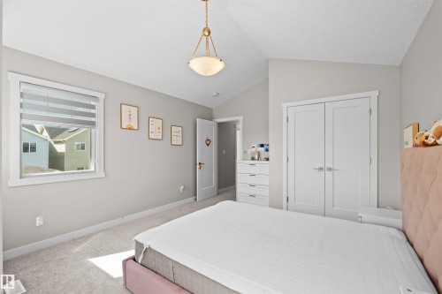 Carpeted room featuring vaulted ceilings and a classic ceiling light fixture - 4673 Alwood Way, Edmonton, AB 