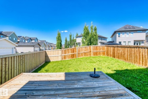Expansive backyard featuring a natural wood deck, manicured lawn, and privacy fencing - 4673 Alwood Way, Edmonton, AB 