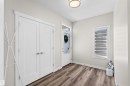 Entryway featuring wood-finish flooring, a contemporary ceiling light fixture, and a front door with glass paneling - 4673 Alwood Way, Edmonton, AB 