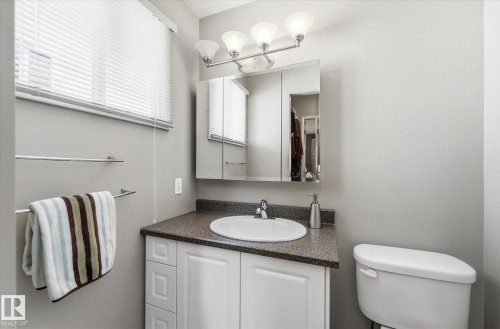Bathroom with white vanity, dark speckled countertop, and integrated sink - 14309 101 Avenue, Edmonton, AB 
