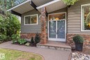 Entryway featuring a double glass panel door, brick facade, and an overhanging roofline - 14309 101 Avenue, Edmonton, AB 