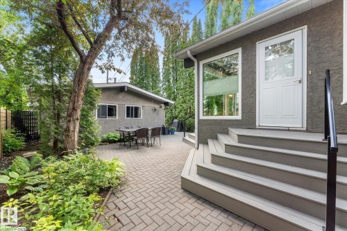 Expansive paver patio with a separate detached structure, mature trees, and established landscaping - 14309 101 Avenue, Edmonton, AB 