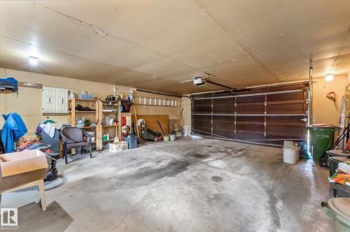 Spacious garage with a sectional overhead door, concrete flooring, and an automatic garage door opener - 14309 101 Avenue, Edmonton, AB 