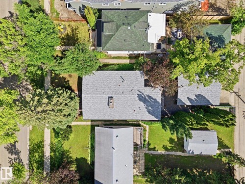 Aerial perspective showcasing a property with a grey shingle roof, mature trees, and a detached structure - 14309 101 Avenue, Edmonton, AB 