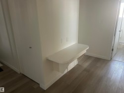Built-in desk featuring a white countertop with integrated electrical outlets - 
