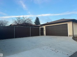 Spacious concrete driveway leading to an attached two-car garage with a panel-style door - 