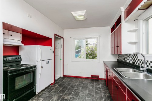 Kitchen featuring dark grey tile flooring and bright red lower cabinetry - 10035 81 Avenue Nw, Edmonton, AB - Indoor Photo Showing Kitchen With Double Sink