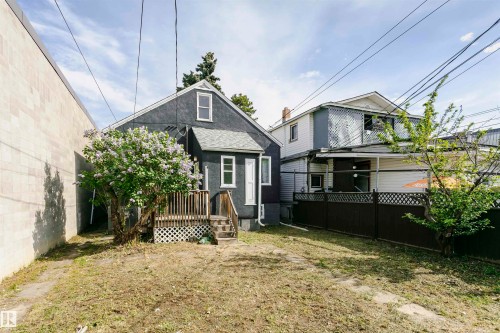 Rear exterior of a dark-toned residential structure featuring white trim windows and a gabled roof - 10035 81 Avenue Nw, Edmonton, AB - Outdoor