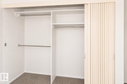 Built-in closet system with multiple rods, shelving, and sliding louvered doors - 