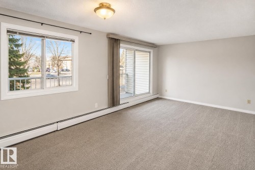 Neutral paint palette with wall-to-wall carpeting - #223 5125 Riverbend Rd Nw, Edmonton, AB - Indoor Photo Showing Other Room