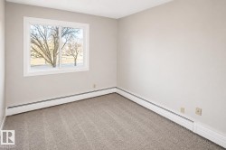 Light gray wall paint, white window trim, horizontal sliding window, gray carpet flooring, baseboard heating system - 
