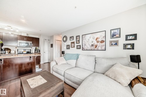 Open-concept living area with wood-finish flooring - 311 142 Ebbers Boulevard, Edmonton, AB 