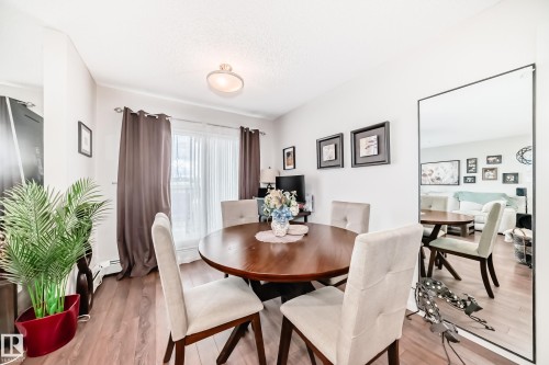 Dining area featuring wood-finish flooring and a ceiling-mounted light fixture - 311 142 Ebbers Boulevard, Edmonton, AB 