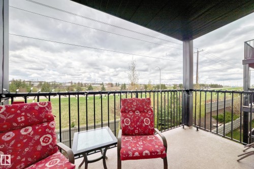 Covered balcony featuring a concrete floor, black metal railings, and an open outdoor expanse - 311 142 Ebbers Boulevard, Edmonton, AB 