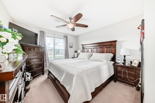 Bedroom with neutral-toned carpeting and a large window - 311 142 Ebbers Boulevard, Edmonton, AB 