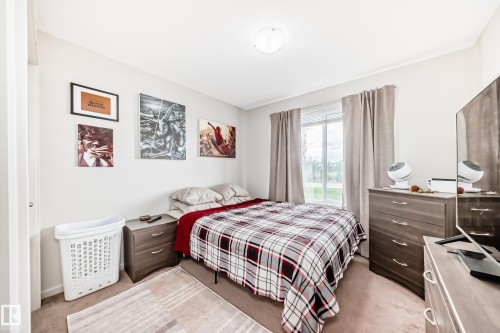 Carpeted room with a double-pane window, neutral walls, and a ceiling-mounted light fixture - 311 142 Ebbers Boulevard, Edmonton, AB 