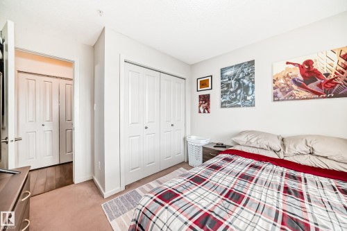 Neutral wall paint, carpeted flooring, and a large bi-fold closet with white panel doors - 311 142 Ebbers Boulevard, Edmonton, AB 