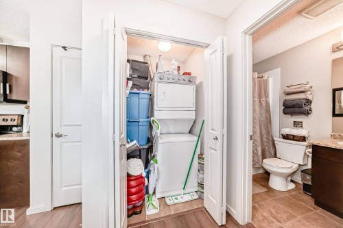 Compact laundry closet featuring a stacked washer and dryer - 311 142 Ebbers Boulevard, Edmonton, AB 