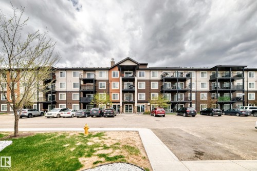 Multi-story building featuring a facade with brown and light-colored siding, multiple private balconies with dark railings, and prominent windows throughout - 311 142 Ebbers Boulevard, Edmonton, AB 