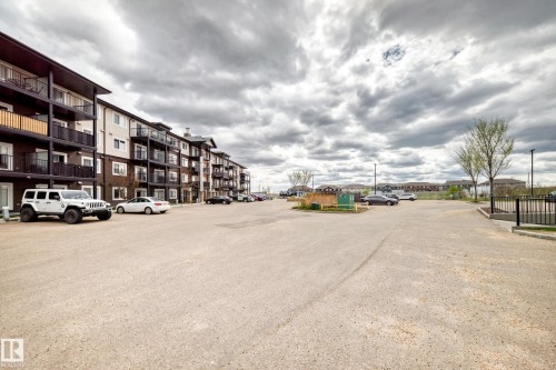 Multi-story residential building featuring dark siding, light-colored panels, and individual balconies with dark railings - 311 142 Ebbers Boulevard, Edmonton, AB 
