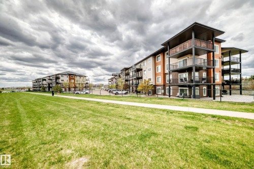 Multi-story building featuring contemporary architecture with stacked balconies and ground-level patios - 311 142 Ebbers Boulevard, Edmonton, AB 