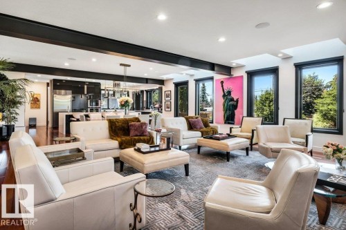 Open-concept living space featuring high ceilings with exposed beams, recessed lighting, and multiple large windows with dark trim - 8914 120 Street, Edmonton, AB 