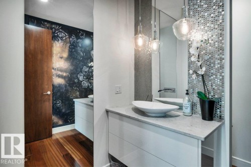 Modern vanity featuring a vessel sink, stone-finish countertop, and decorative pendant lighting - 8914 120 Street, Edmonton, AB 