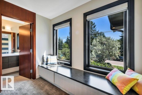 Integrated window seat with built-in storage, featuring a dark countertop and two large windows - 8914 120 Street, Edmonton, AB 
