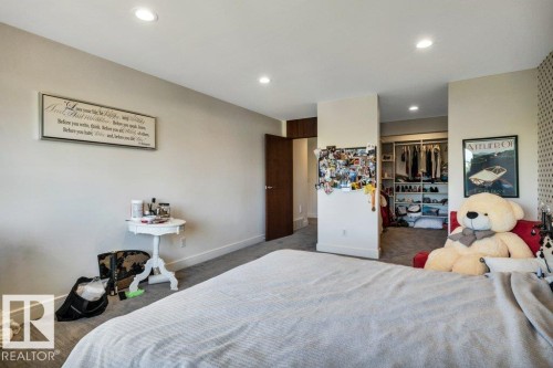 Spacious room featuring neutral painted walls, recessed lighting, carpet flooring, and a walk-in closet with built-in shelving - 8914 120 Street, Edmonton, AB 